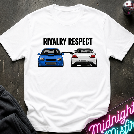A white short-sleeve graphic T-shirt laid flat on a dark textured surface. The shirt features the text 'RIVALRY RESPECT' above a front-facing blue sports car and a rear-facing white sports car.
