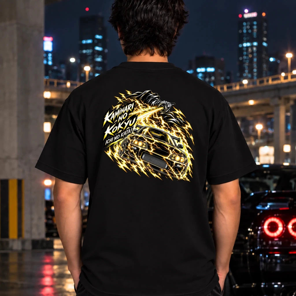 man wearing a black t-shirt showing the back graphic with a car and the text "ichi no kata!"