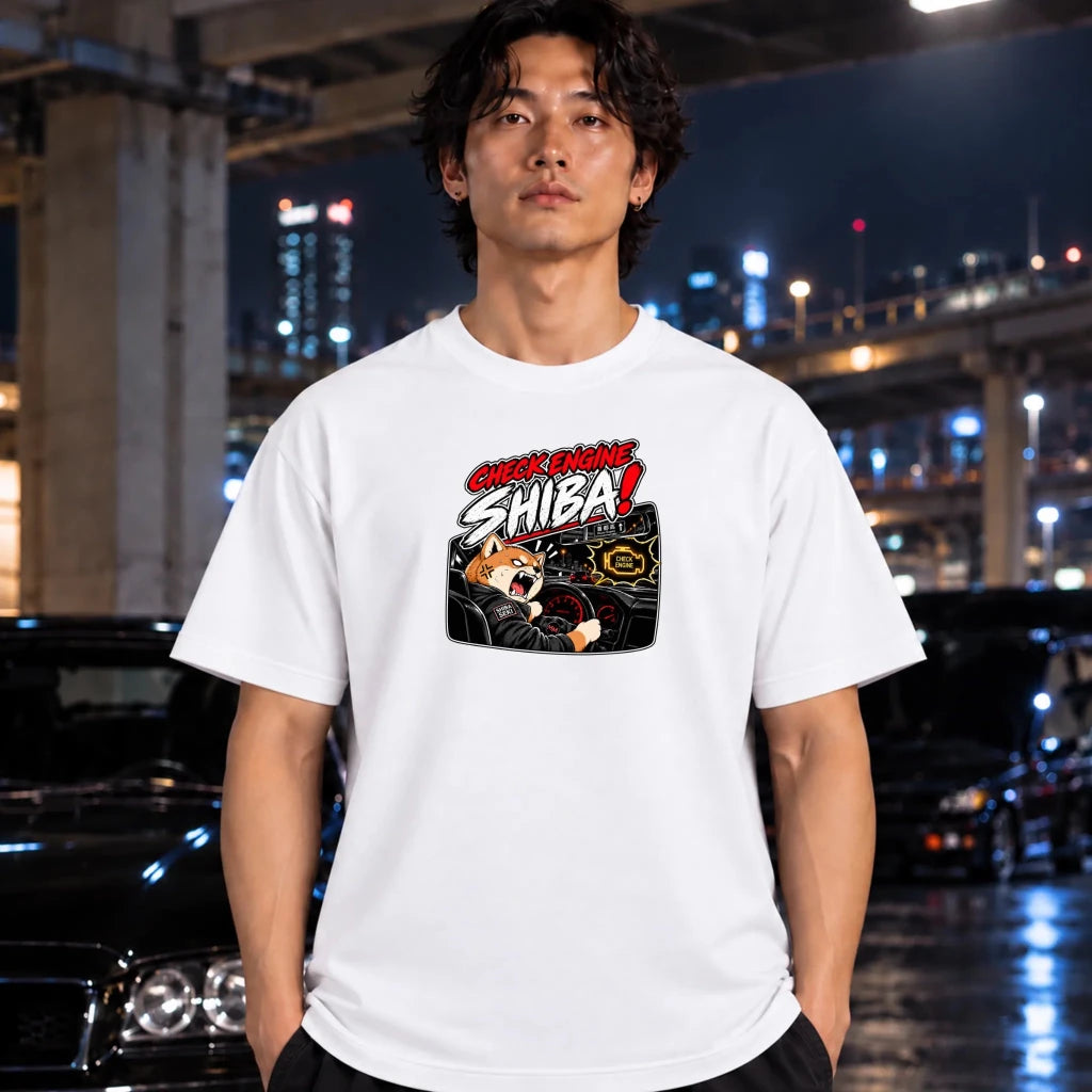 man wearing white t-shirt featuring a graphic print of a Shiba Inu dog driving a car with the text 'CHECK ENGINE SHIBA!' in red and white
