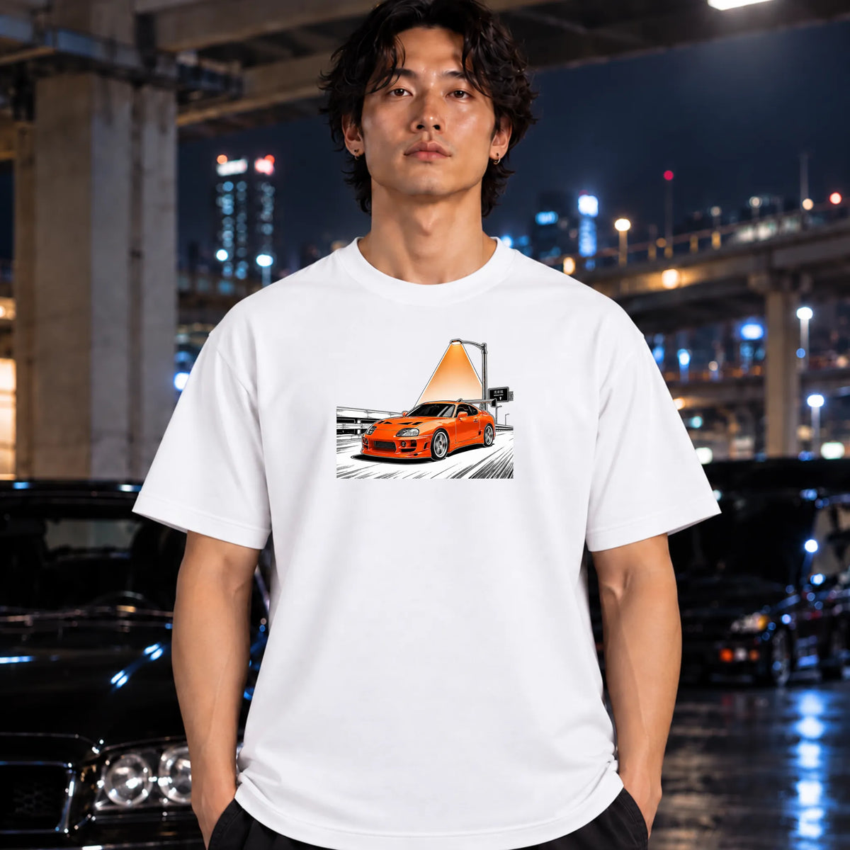 man wearing a white short-sleeve t-shirt, featuring a graphic print of an orange sports car speeding on highway.