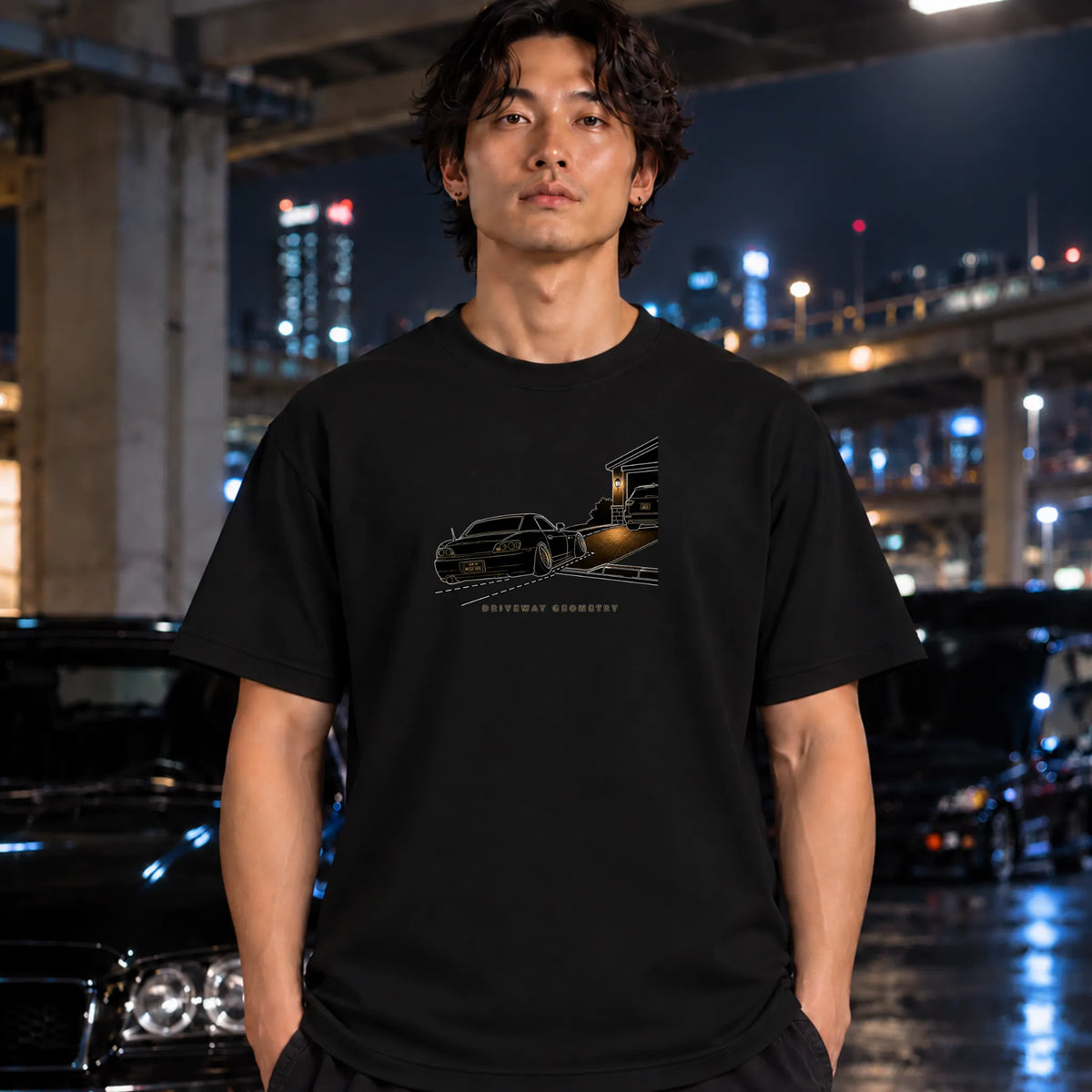 man wearing a black t-shirt featuring a graphic print of a black classic car going up the driveway.