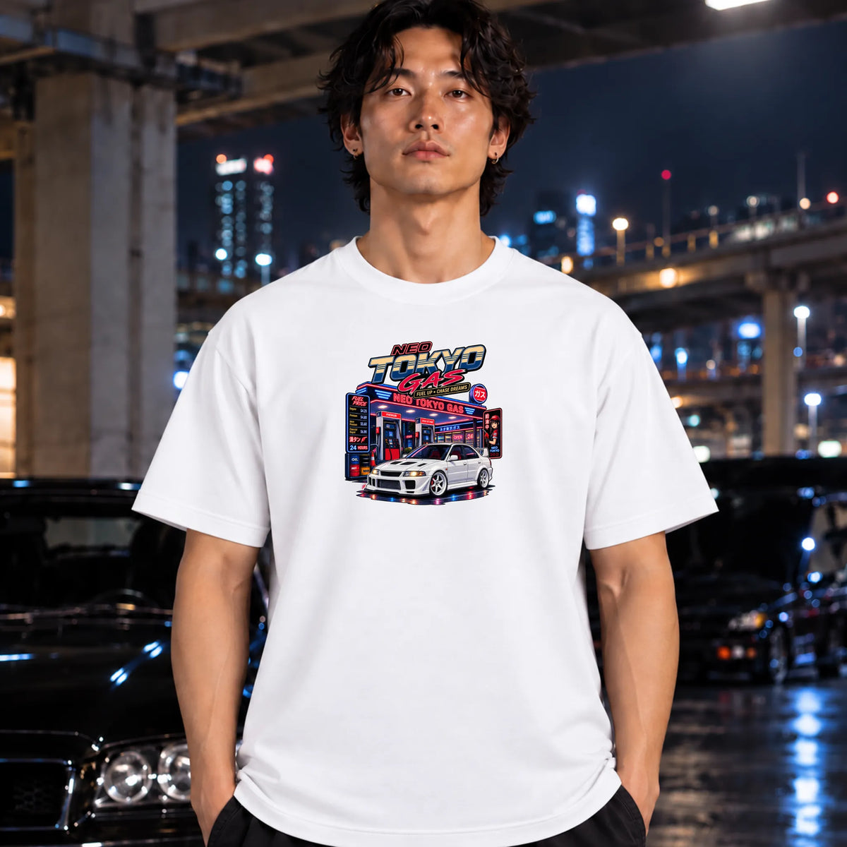 man wearing white short-sleeve t-shirt with a colorful graphic print of a 'Neo Tokyo Gas" arcade and a black sports car,