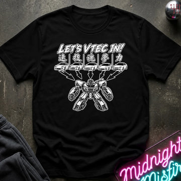 A black short-sleeve graphic t-shirt laid flat on a dark textured surface. The shirt features a white graphic print with the text 'LET'S VTEC IN!' and stylized car illustrations.