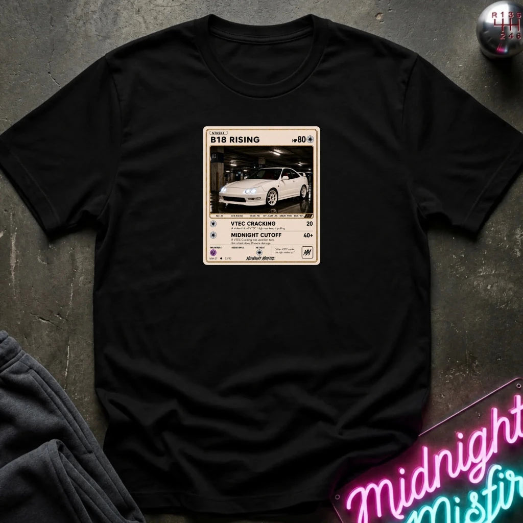 black crewneck t-shirt laid flat on a dark textured surface. The shirt features a graphic print styled like a retro card