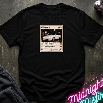 black crewneck t-shirt laid flat on a dark textured surface. The shirt features a graphic print styled like a retro card