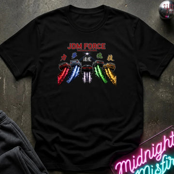 A black short-sleeve graphic T-shirt laid flat on a dark textured surface. The shirt features a colorful chest print with the words 'JDM FORCE' in red and stylized Japanese characters above four car silhouettes with red, blue, white, and green trails.