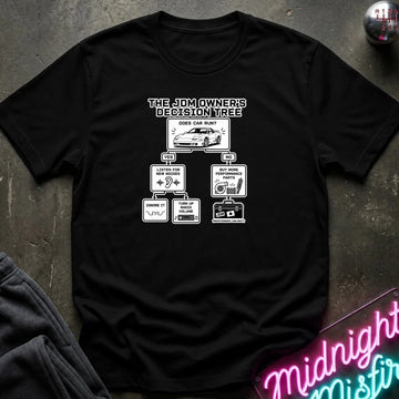 A black short-sleeve graphic T-shirt laid flat on a dark textured surface. The shirt features a white printed decision tree graphic titled 'THE JDM OWNER'S DECISION TREE' with illustrations and text related to car parts and maintenance.