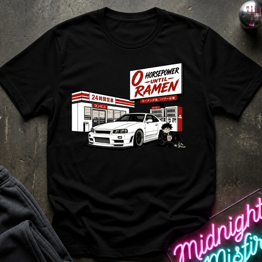 A black short-sleeve graphic t-shirt laid flat on a dark textured surface. The graphic features a white sports car in front of a store with a sign reading 'O HORSEPOWER UNTIL RAMEN'.