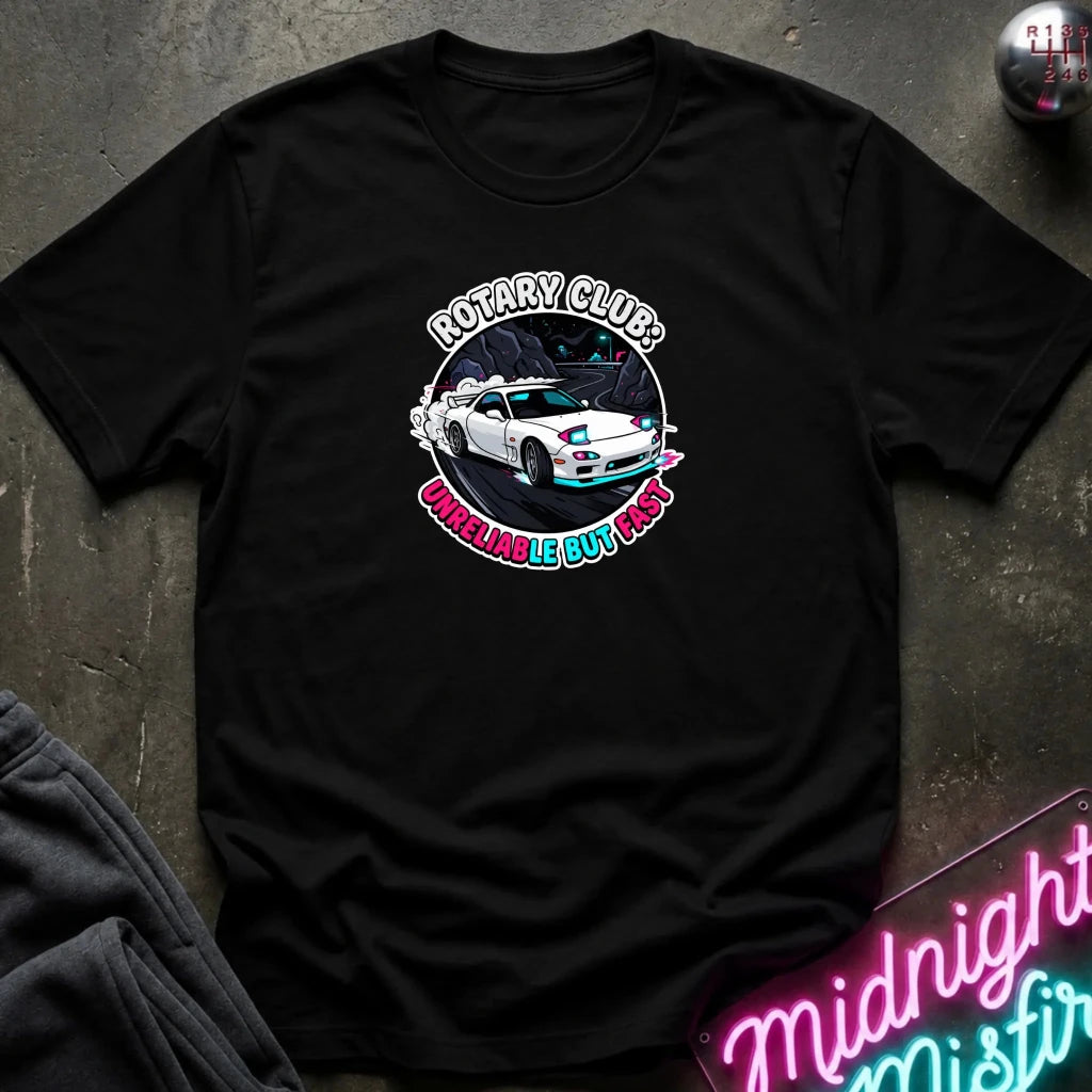 A black crewneck t-shirt laid flat on a dark textured surface. The shirt features a circular graphic print in the center showing a white sports car with blue and pink accents, surrounded by the text 'ROTARY CLUB!