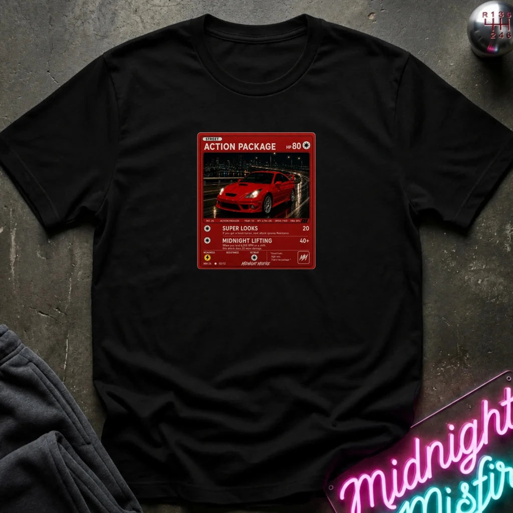 black crewneck t-shirt laid flat on a dark textured surface, featuring a red graphic print vintage card and a car.