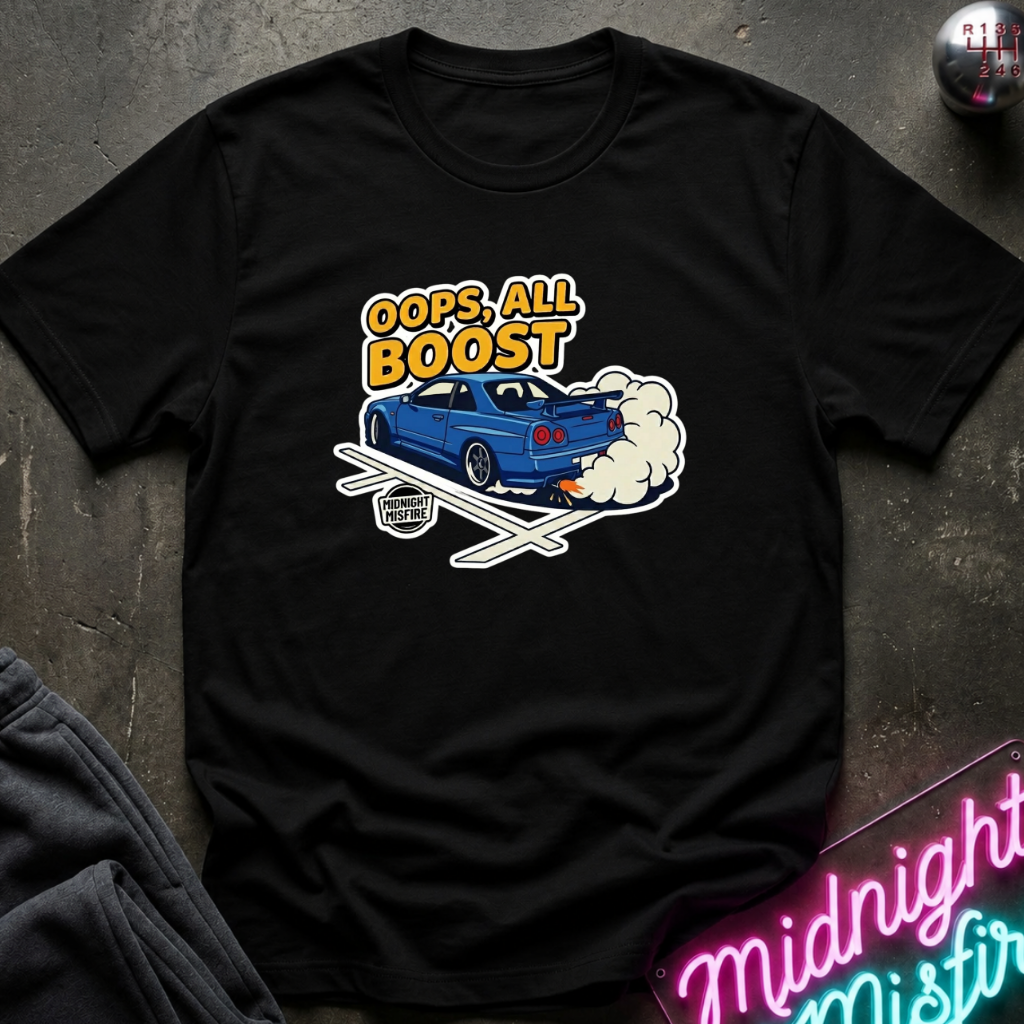 A black short-sleeve graphic t-shirt laid flat on a dark textured surface. The graphic features a blue sports car with white smoke and the text 'OOPS, ALL BOOST' in yellow and white.