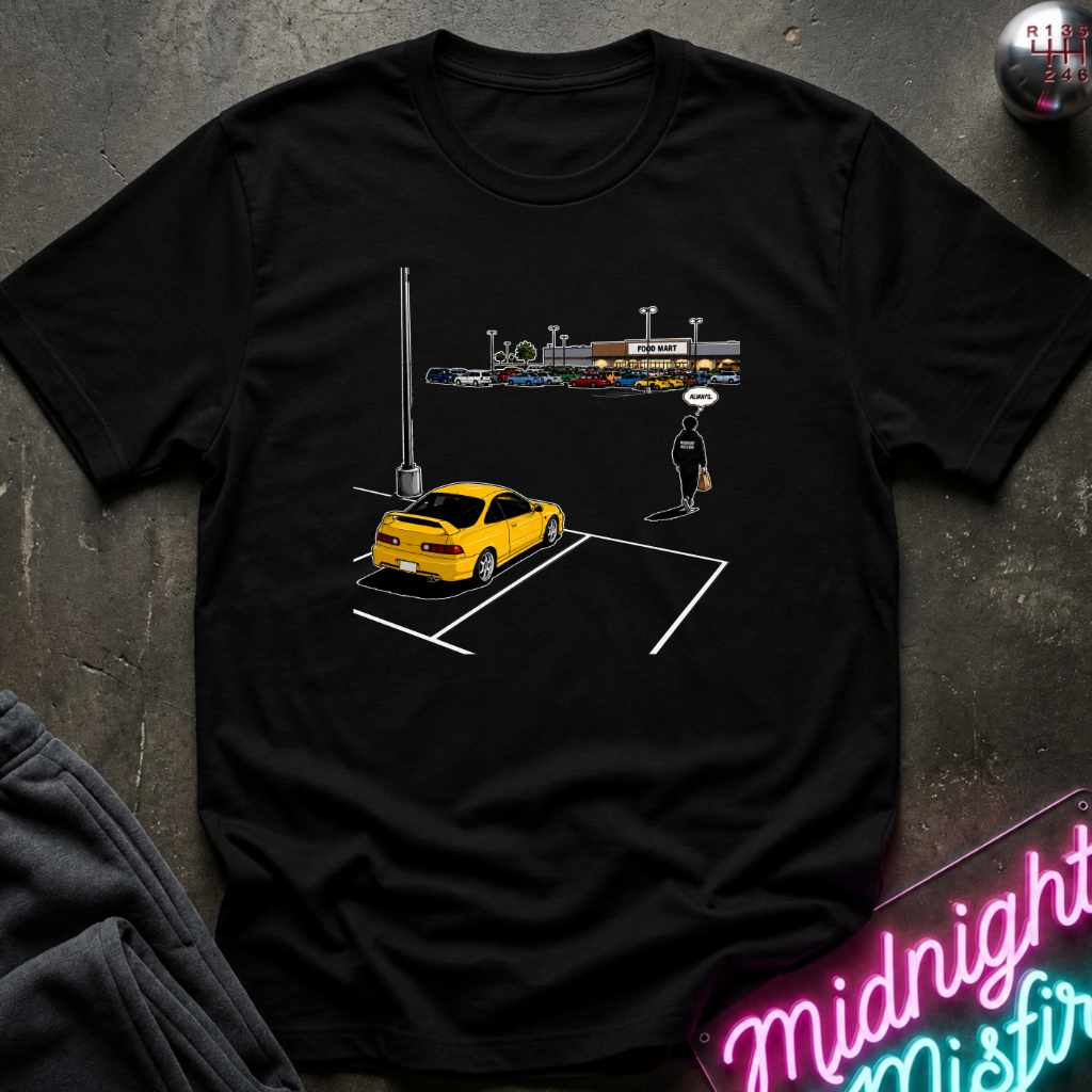 A black short-sleeve graphic t-shirt laid flat on a dark textured surface. The graphic shows a yellow sports car parked in a marked spot.