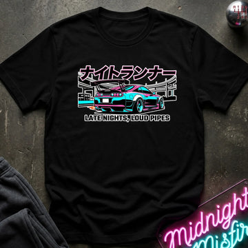 A black short-sleeve graphic T-shirt laid flat on a dark textured surface. The shirt features a colorful print of a sports car with Japanese text above and the phrase 'LATE NIGHTS, LOUD PIPES' below.