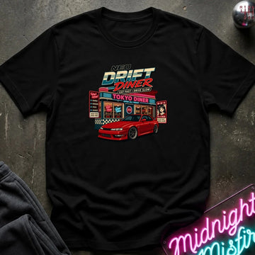 A black short-sleeve graphic t-shirt laid flat on a dark textured surface. The shirt features a colorful retro-style print of a red sports car parked in front of a neon-lit 'Neon Drift Diner' sign.