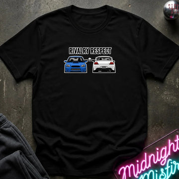 A black short-sleeve graphic t-shirt laid flat on a dark textured surface. The graphic features the text 'RIVALRY RESPECT' above a blue sports car facing a white sports car.