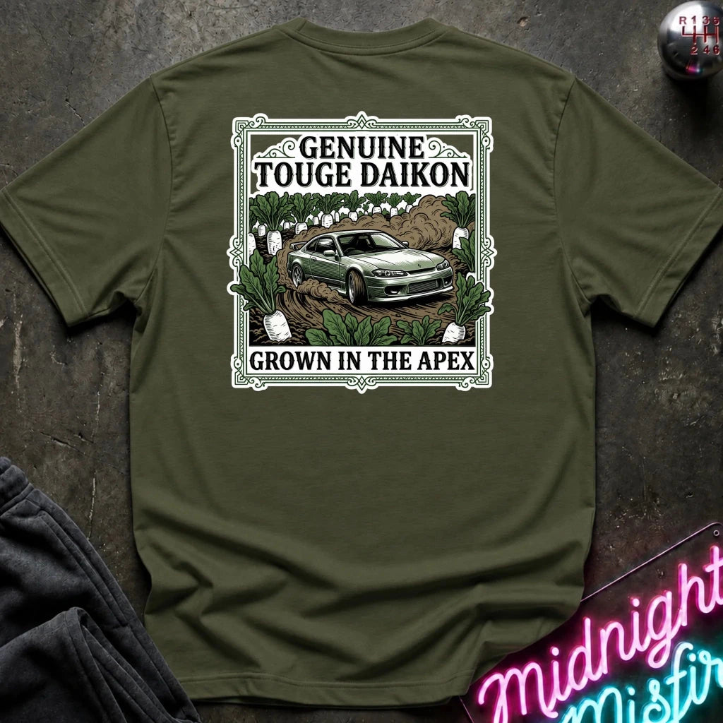 An olive green short-sleeve graphic T-shirt laid flat on a dark textured surface. The shirt features a rectangular vintage-style print with the words 'Genuine Touge Daikon' and 'Grown in the Apex' surrounding an illustration of a green car in a field.