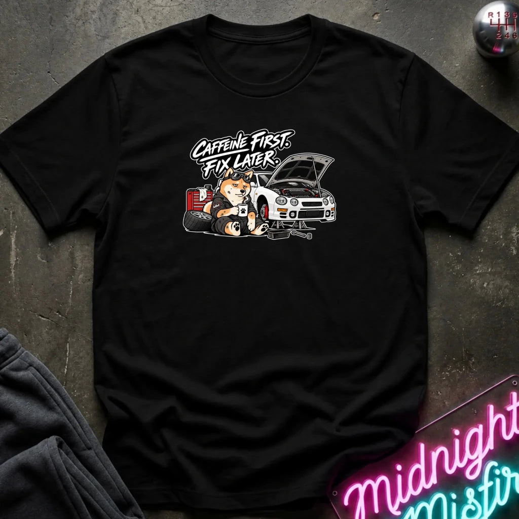black short-sleeve crewneck t-shirt laid flat on a dark textured surface. The shirt features a graphic print of shiba inu dog.