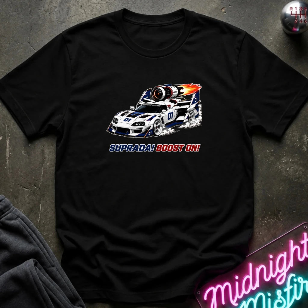 A black short-sleeve graphic t-shirt laid flat on a dark textured surface. The shirt features a white and blue race car with a fiery exhaust effect and the text 'SUPRADA BOOST 4N!' printed below it.