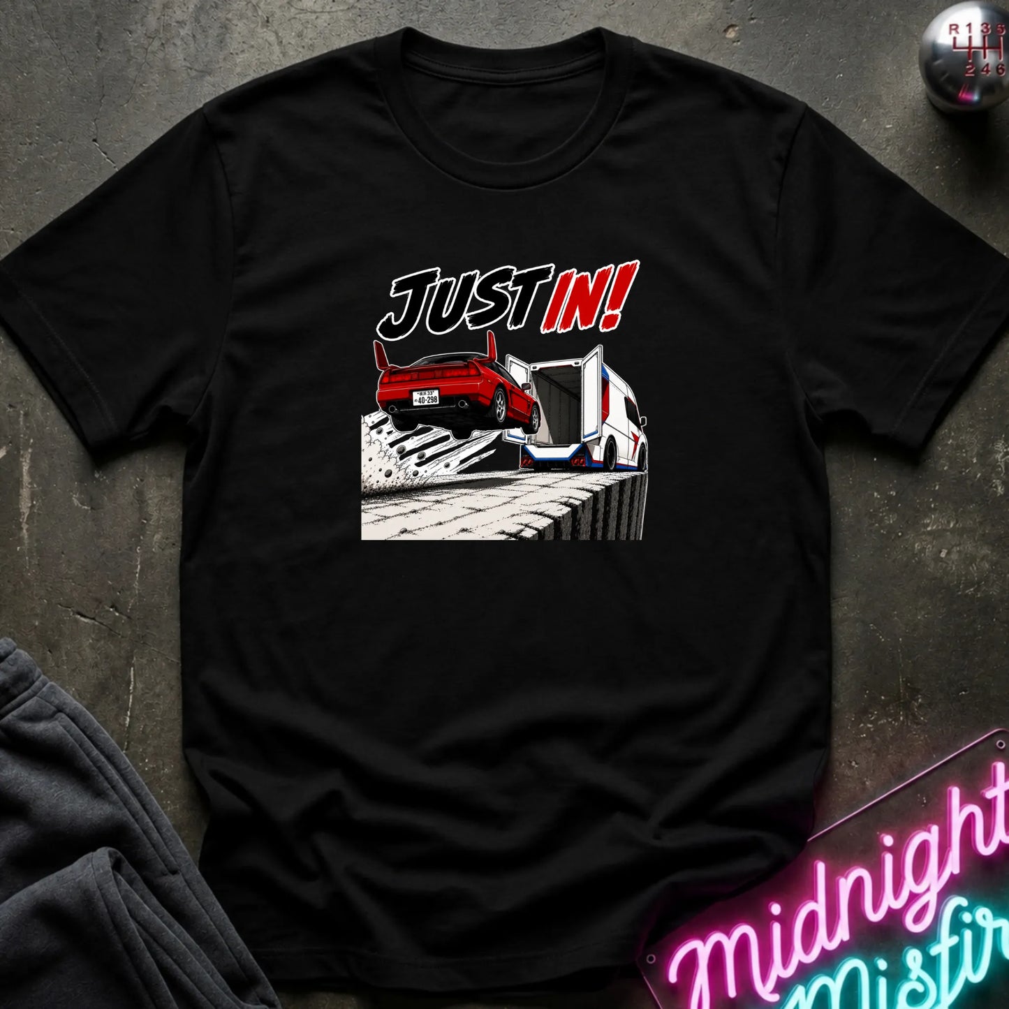 A black short-sleeved t-shirt  that has a red car jumping into back of another machine.