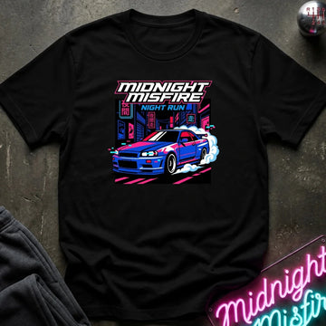 A black short-sleeve graphic t-shirt laid flat on a dark textured surface. The shirt features a colorful retro-style print of a blue sports car drifting in front of neon signs, with the text 'MIDNIGHT MISFIRE' and 'NIGHT RUN'.