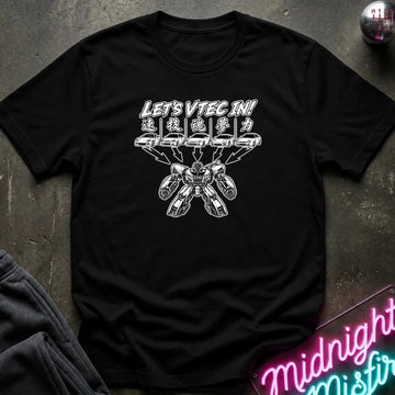 A black short-sleeve graphic T-shirt laid flat on a dark textured surface. The shirt features a white printed design with the text 'LET'S VTEC IN!' 