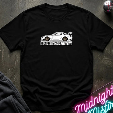 A black short-sleeve t-shirt laid flat on a dark textured surface, featuring a white sports car graphic and the text 'MIDNIGHT MISFIRE '