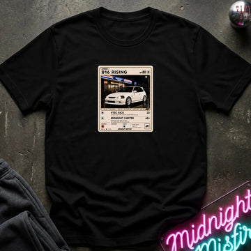 black crewneck t-shirt laid flat on a dark textured surface, featuring a graphic print ofvintage card and a car.