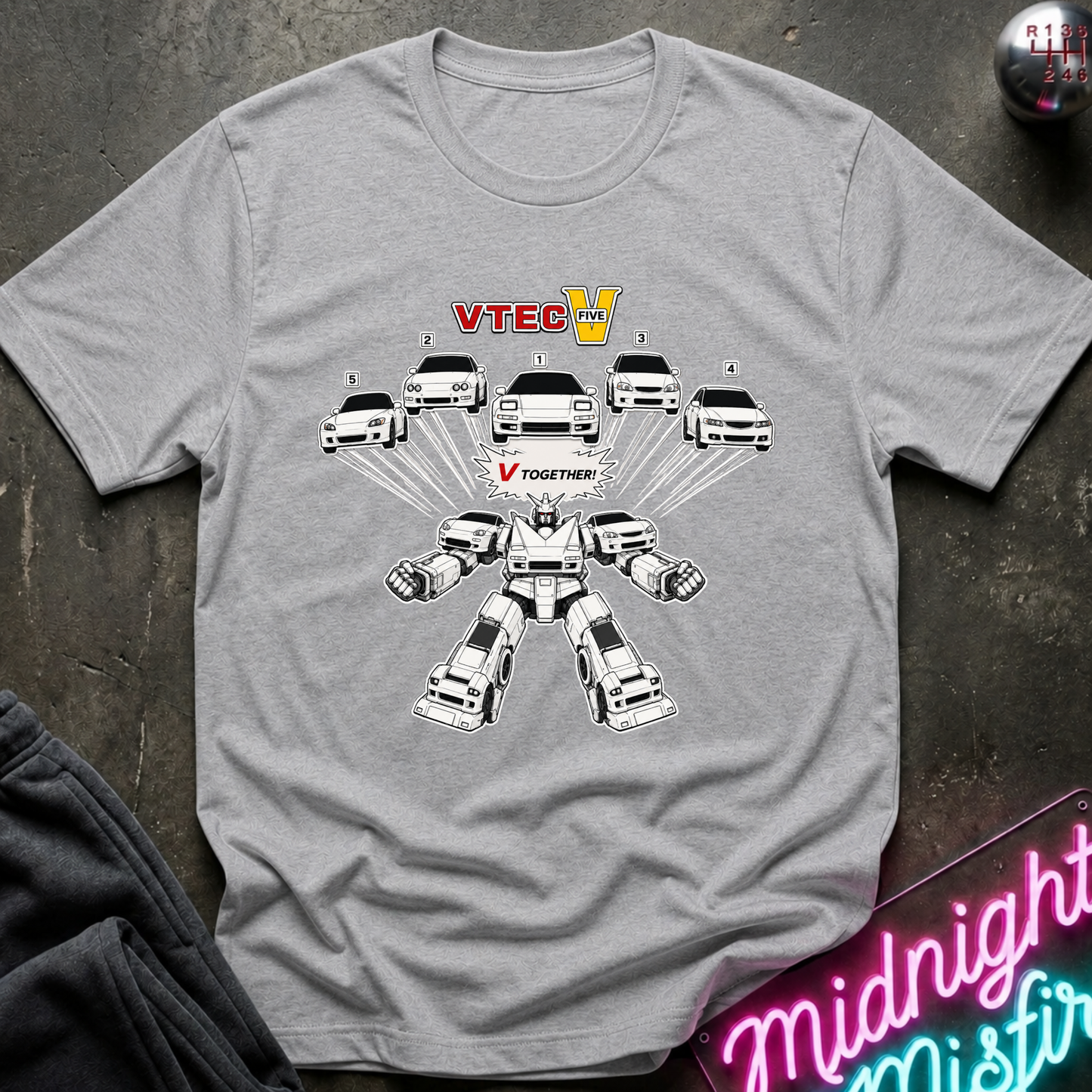 A heather gray short-sleeve t-shirt with a graphic print of a white and black robot transforming from Decepticons to VTEC V  displayed flat on a dark textured surface.