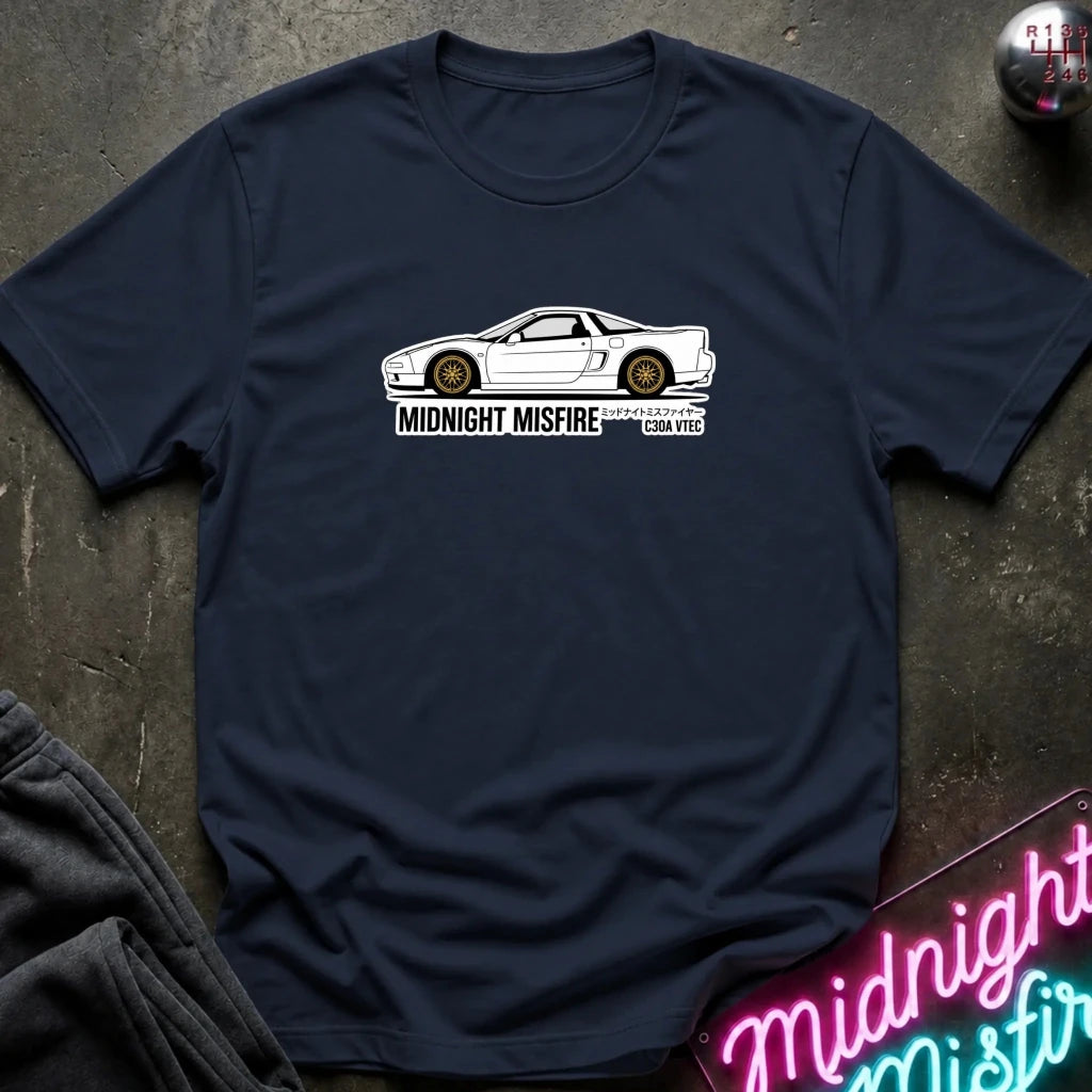 A navy blue short-sleeve t-shirt laid flat on a dark textured surface, featuring a white sports car graphic and the text 'MIDNIGHT MISFIRE '