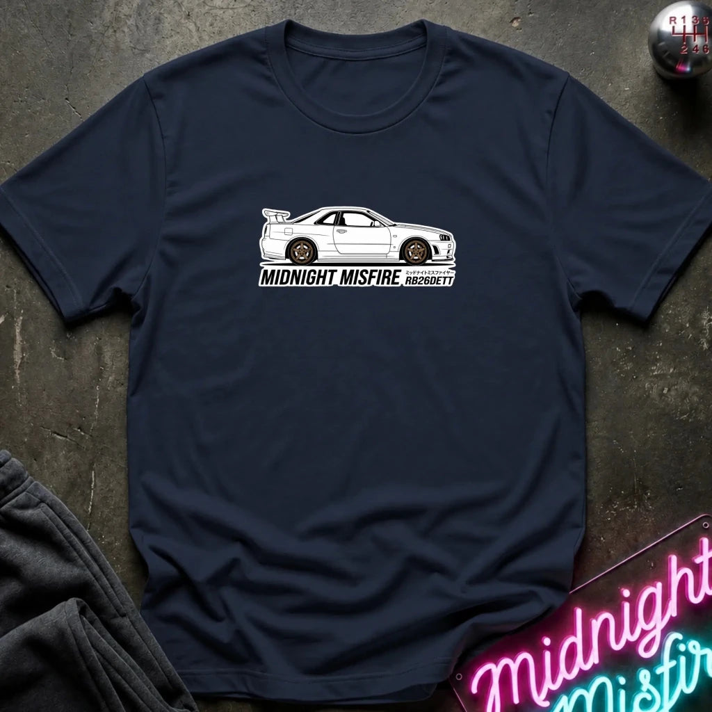 A navy blue short-sleeve t-shirt laid flat on a dark textured surface, featuring a white sports car graphic and the text 'MIDNIGHT MISFIRE '
