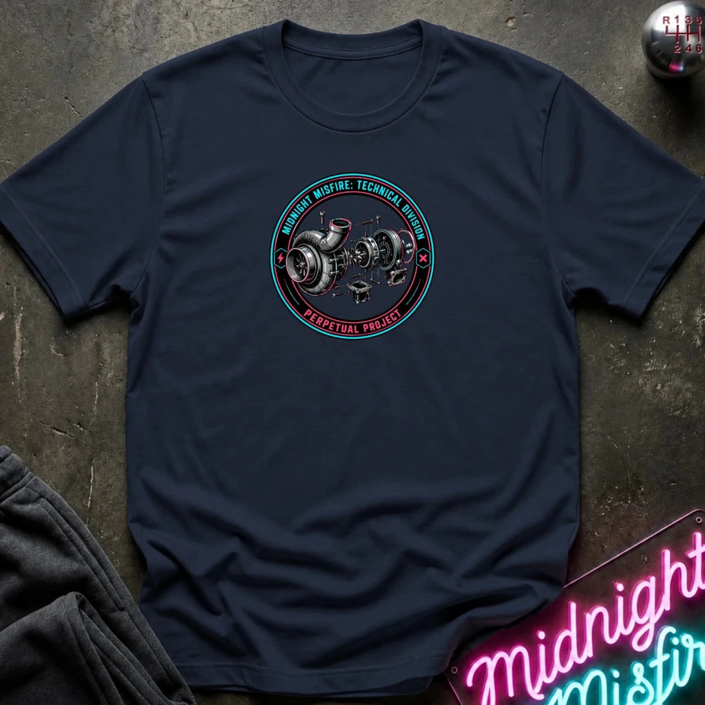 A navy blue crewneck t-shirt laid flat on a dark textured surface, featuring a circular graphic of a turbocharger with the text 