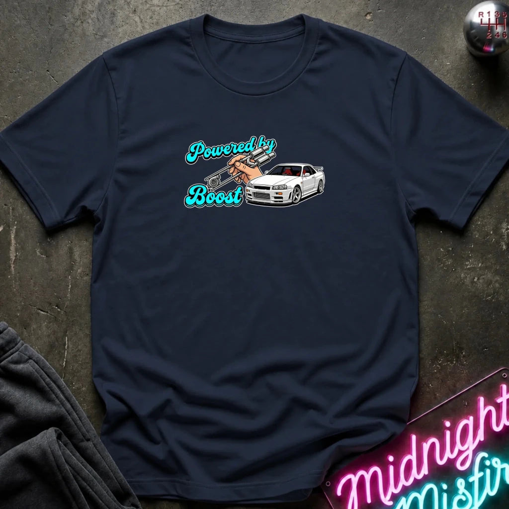 A navy blue short-sleeve t-shirt laid flat on a dark textured surface. The shirt features a graphic print on the chest with the words 'Powered by Boost' in a stylized teal font, alongside an illustration of a hand pushing a white sports car.