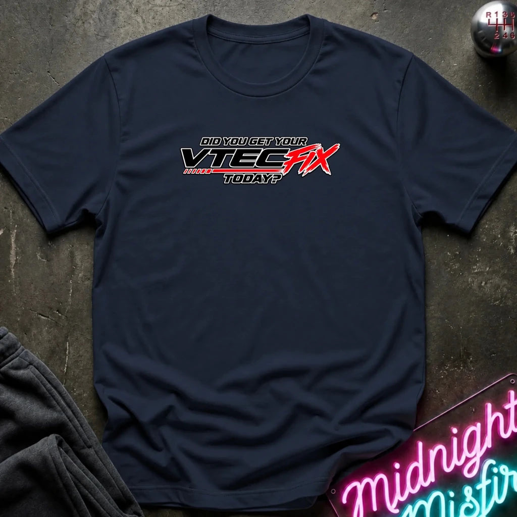 A navy blue crewneck t-shirt laid flat on a dark textured surface, featuring a red and white graphic on the chest that reads 'Did YOU get YOUR VTEC FIX TODAY?'. 