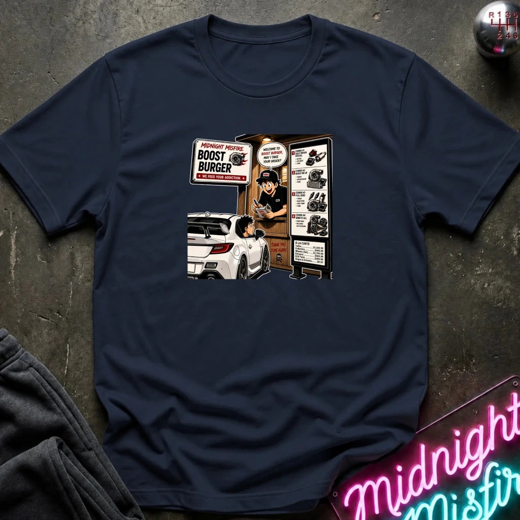 A navy blue short-sleeve crewneck t-shirt with a retro-style graphic print on the front depicting a fast-food burger scene with a car and a sign reading 'BOOST BURGER'. 