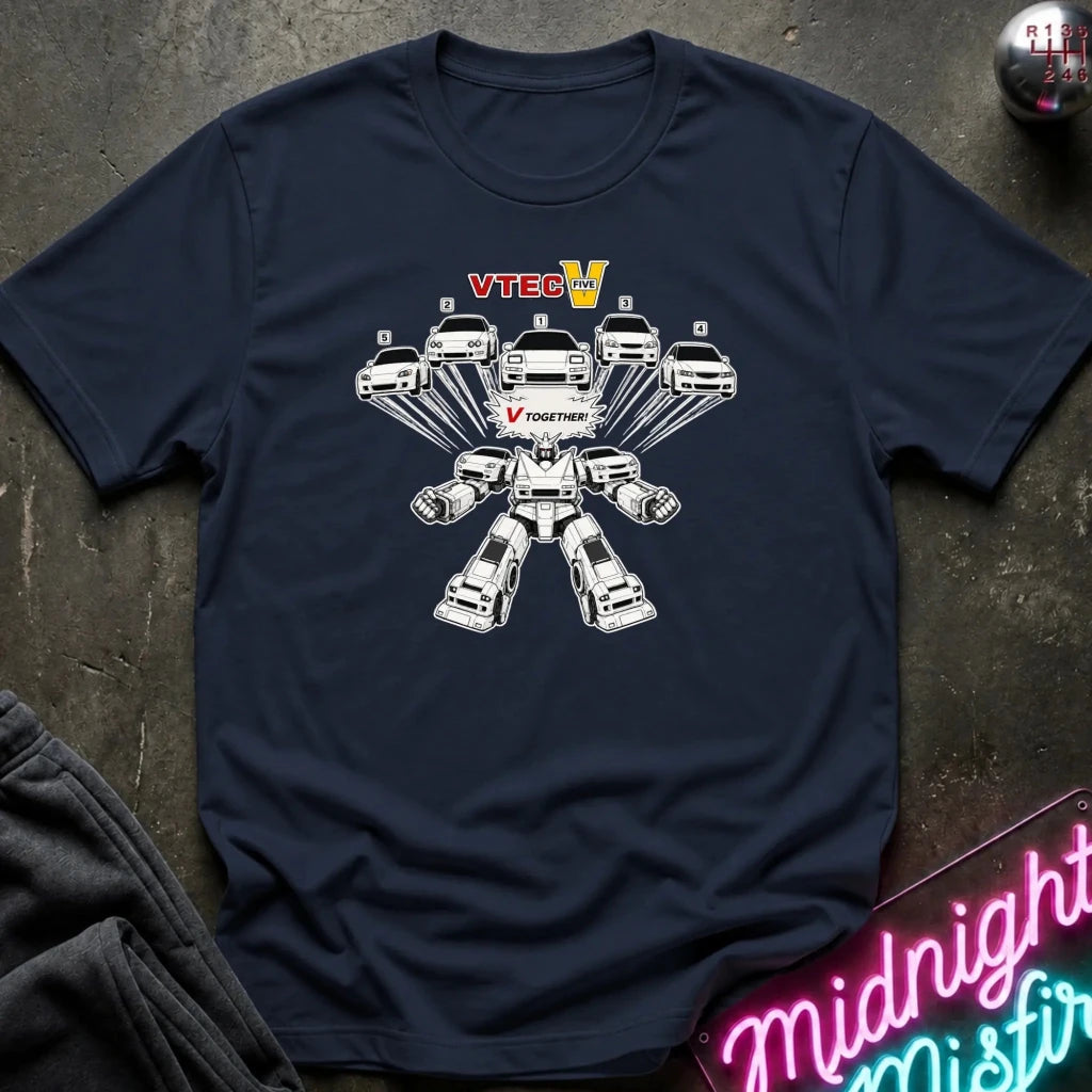 A navy blue crewneck t-shirt laid flat on a dark textured surface. The shirt features a graphic of a white cars into robot