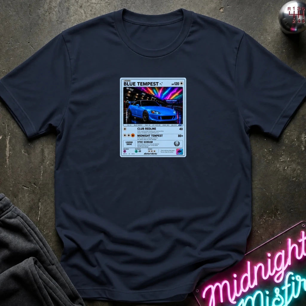 navy crewneck t-shirt laid flat on a dark textured surface, featuring a graphic print of vintage card and a car.