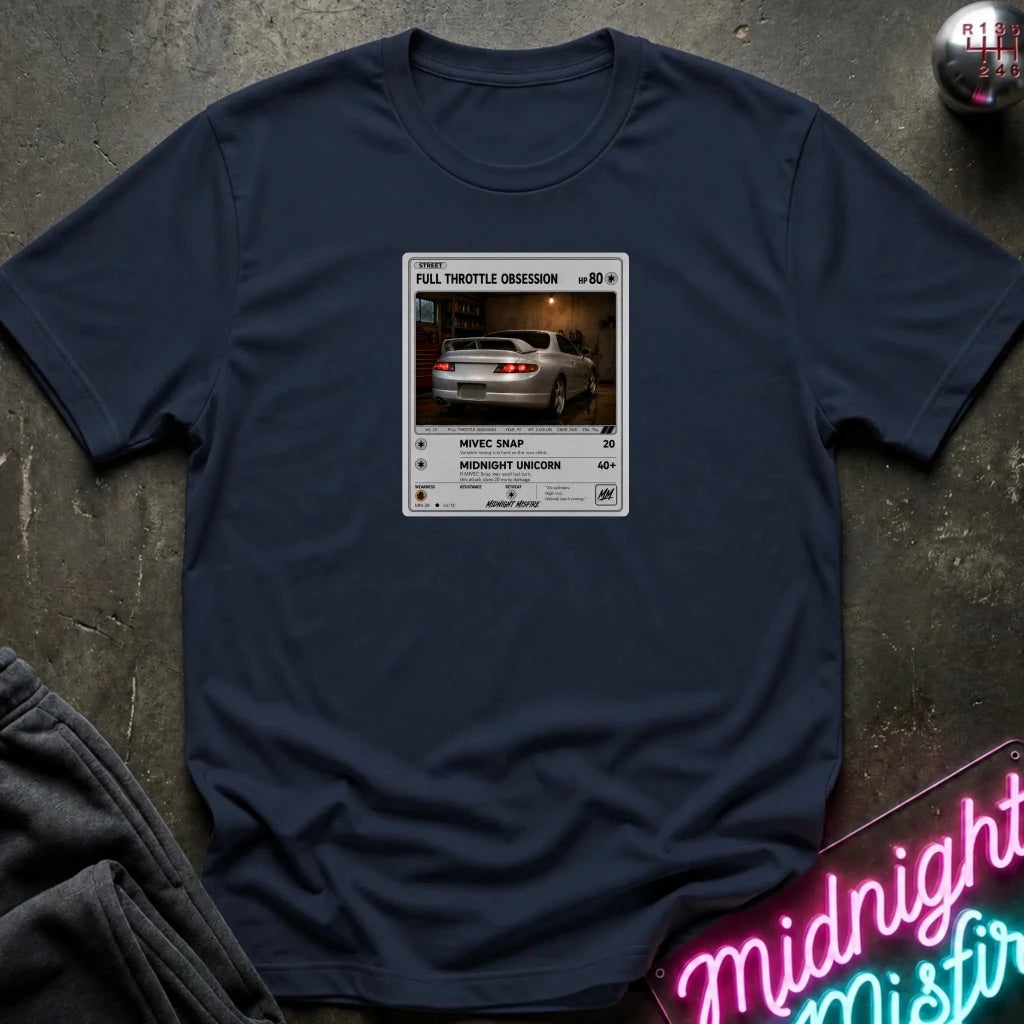 navy crewneck t-shirt laid flat on a dark textured surface. The shirt features a graphic print styled like a retro card
