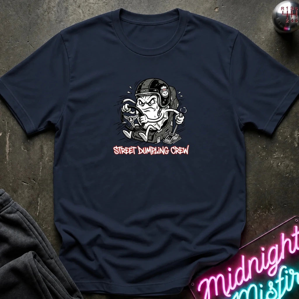 A navy blue crewneck t-shirt laid flat on a dark textured surface. The shirt features a graphic of a street-dumper character wearing a helmet and goggles, with the text 'STREET DUMPING CREW' printed below in a pink font.