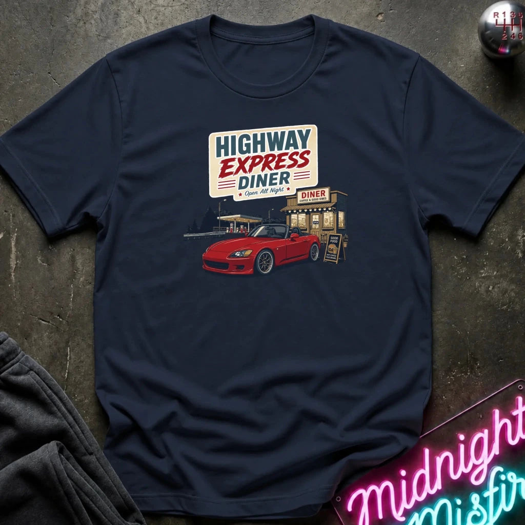 A navy blue short-sleeve t-shirt laid flat on a dark textured surface, featuring a retro-style graphic of a red sports car parked outside a diner with the sign 'Highway Express Diner'.