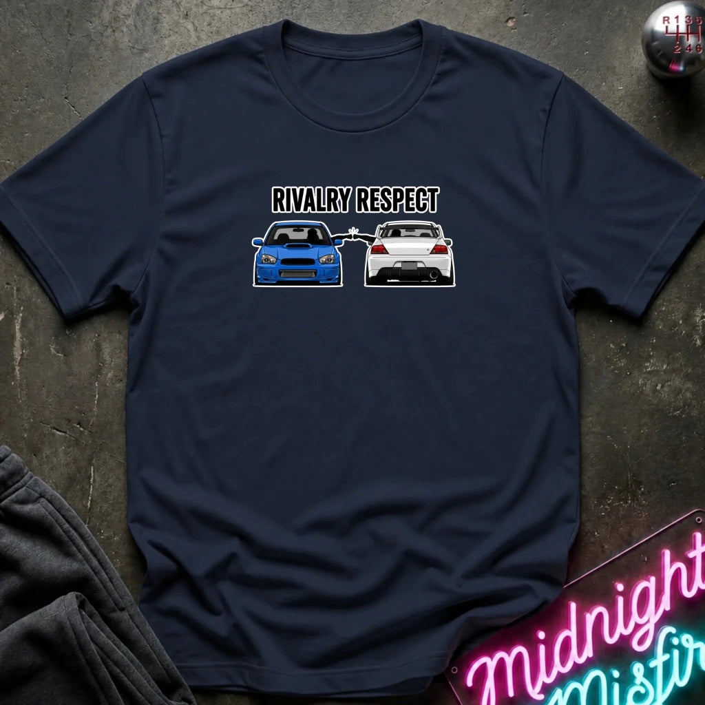 A navy blue graphic t-shirt laid flat on a dark textured surface. The graphic features the text 'RIVALRY RESPECT' above a blue car facing a white car.