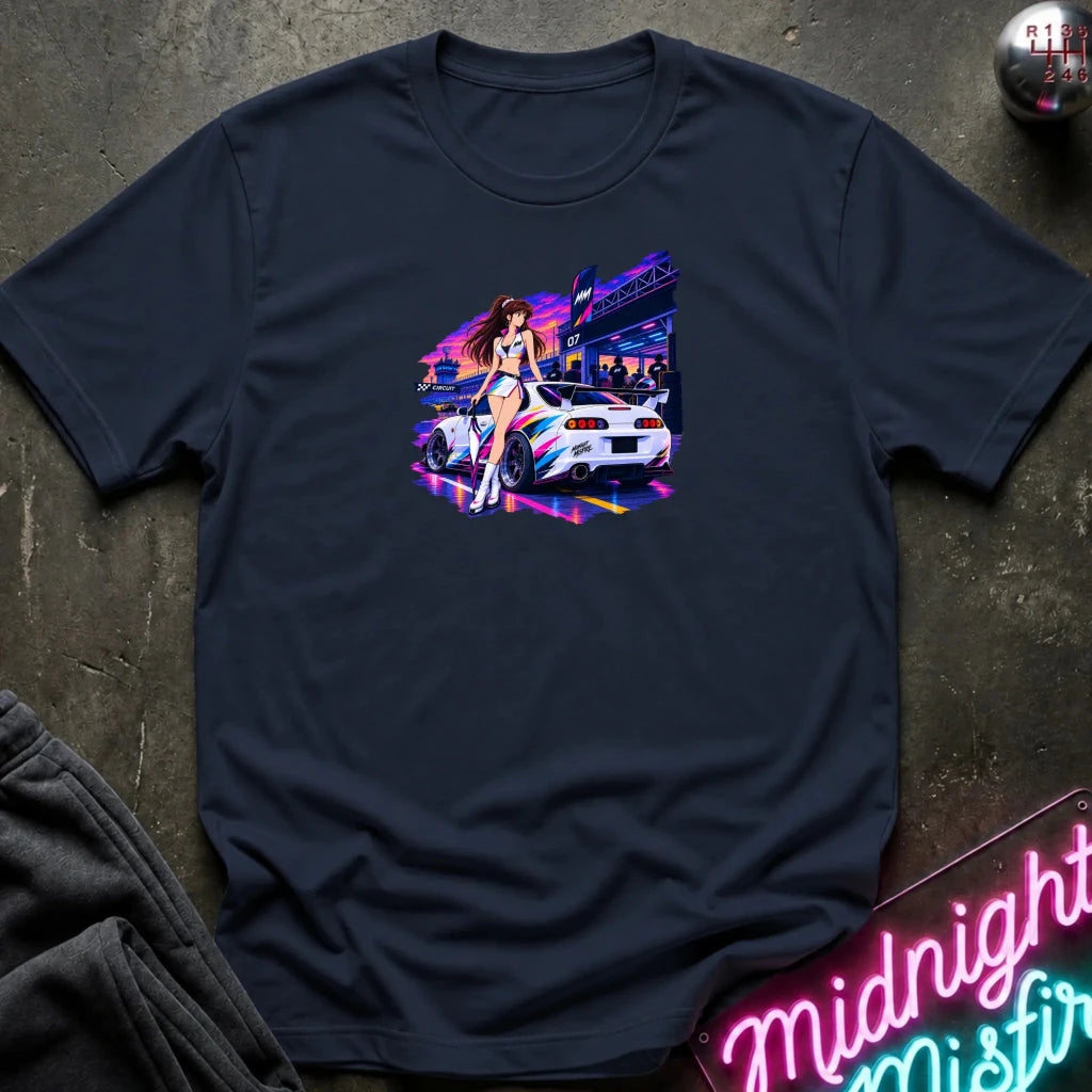 A navy blue  short-sleeve t-shirt laid flat on a dark textured surface, featuring a colorful graphic print of a white sports car and a woman in a neon-lit scene. 