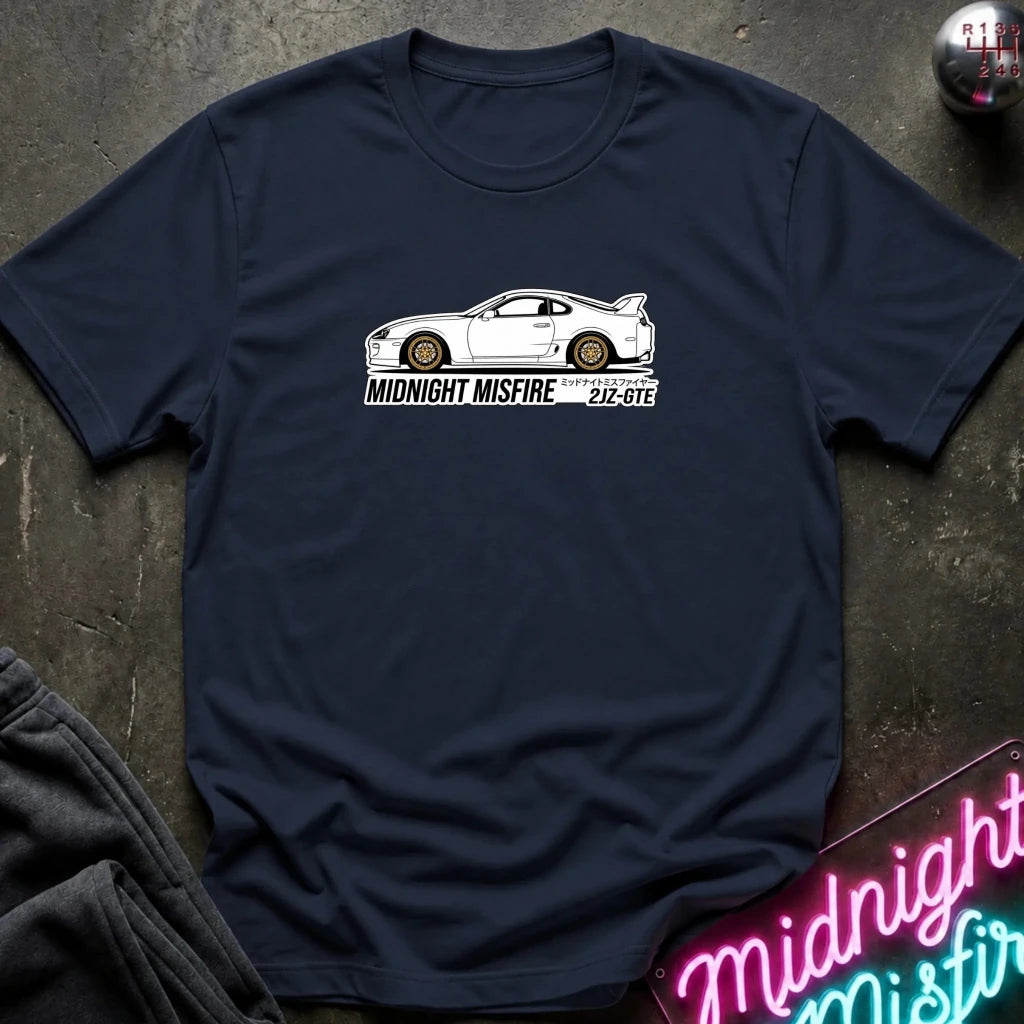 navy short-sleeve t-shirt laid flat on a dark textured surface, featuring a white sports car graphic and the text 'MIDNIGHT MISFIRE '