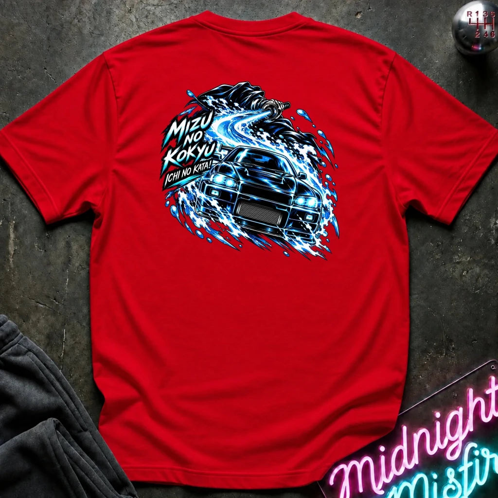 red short-sleeve t-shirt laid flat on a dark textured surface, showing the back graphic with a car and the text "ichi no kata!"