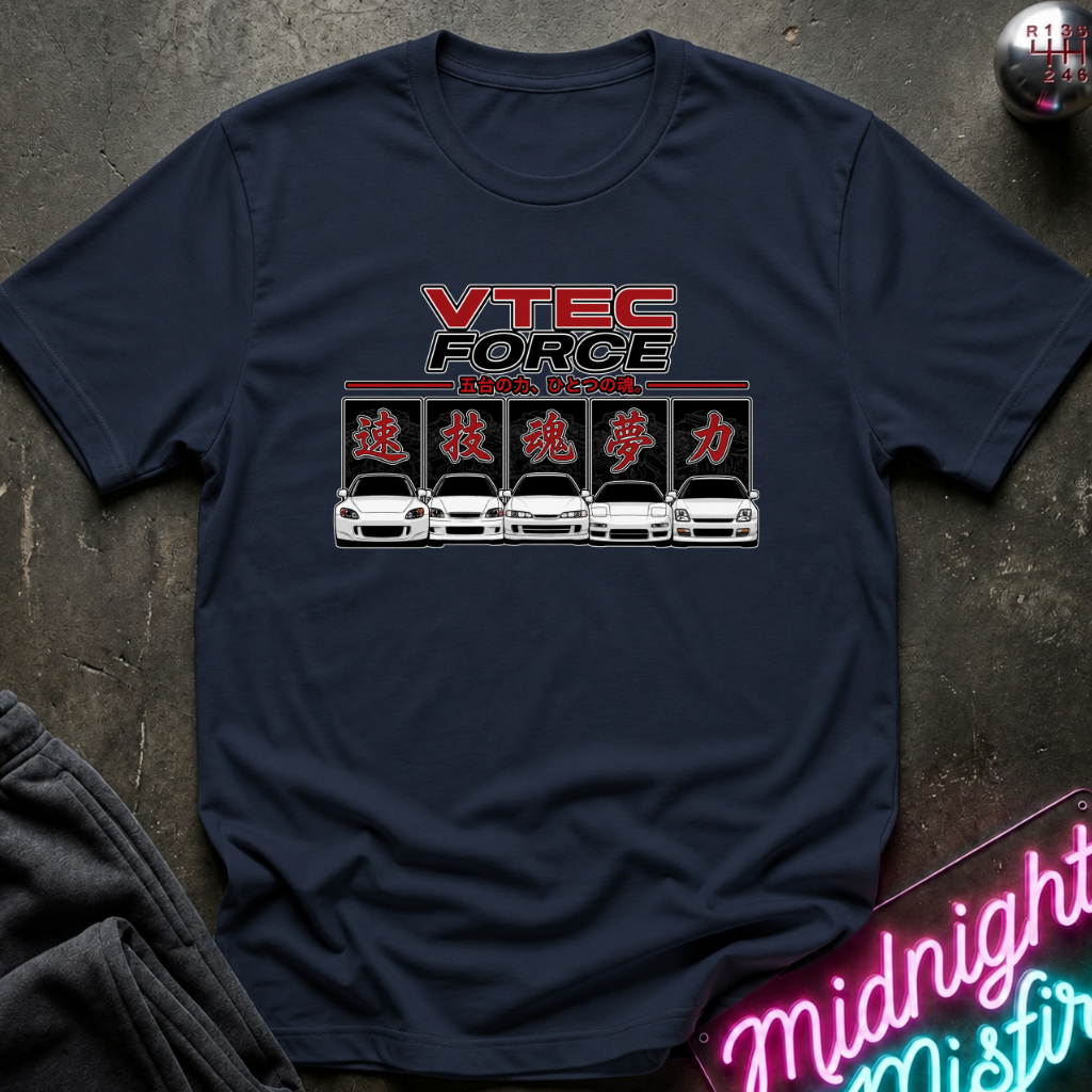 A navy blue short-sleeve t-shirt with a 'VTEC FORCE' car graphic printed on the chest, laid flat on a dark textured surface with a neon sign and dark pants partially visible.
