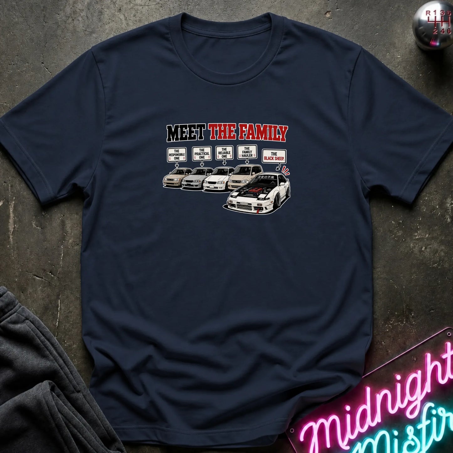 A navy short-sleeved t-shirt  that has a cars parked with one standing out that says black sheep.