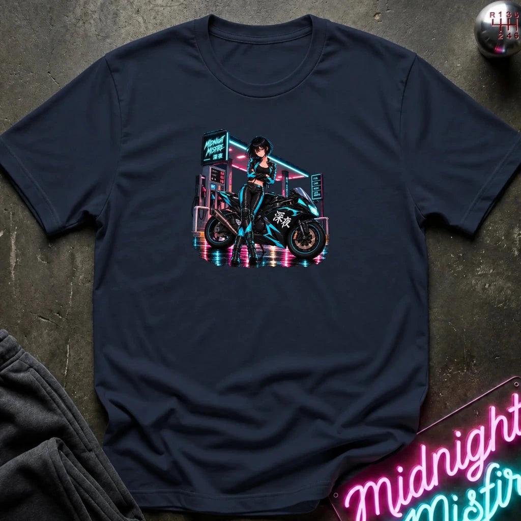 A navy blue short-sleeve t-shirt laid flat on a dark textured surface, featuring a colorful graphic print of a woman riding a motorcycle in a neon cyberpunk city scene. 