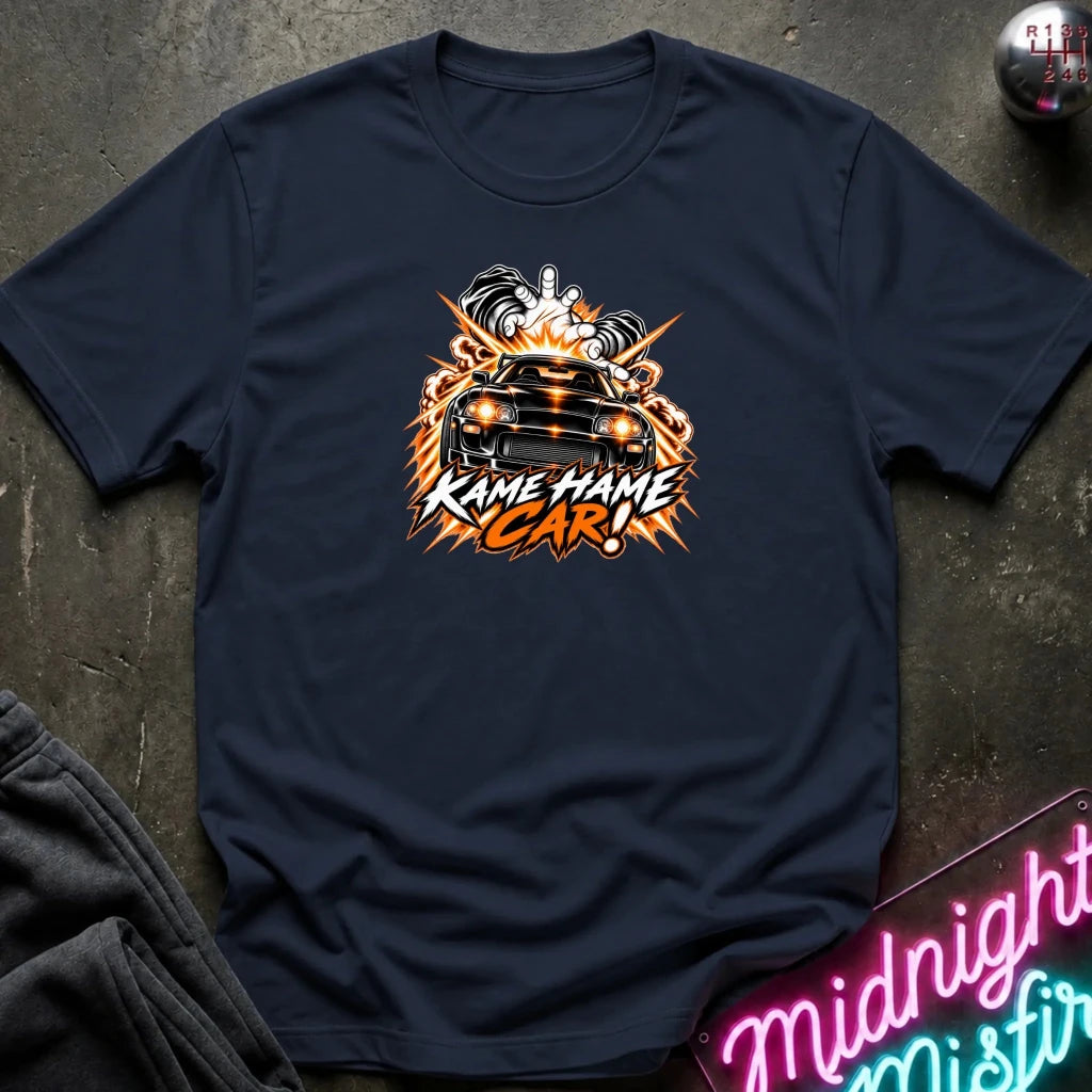 navy short-sleeve graphic t-shirt laid flat on a dark textured surface. The shirt features a red, white, and black graphic of a car with the text 'KAME HAME CAR!' in stylized lettering.