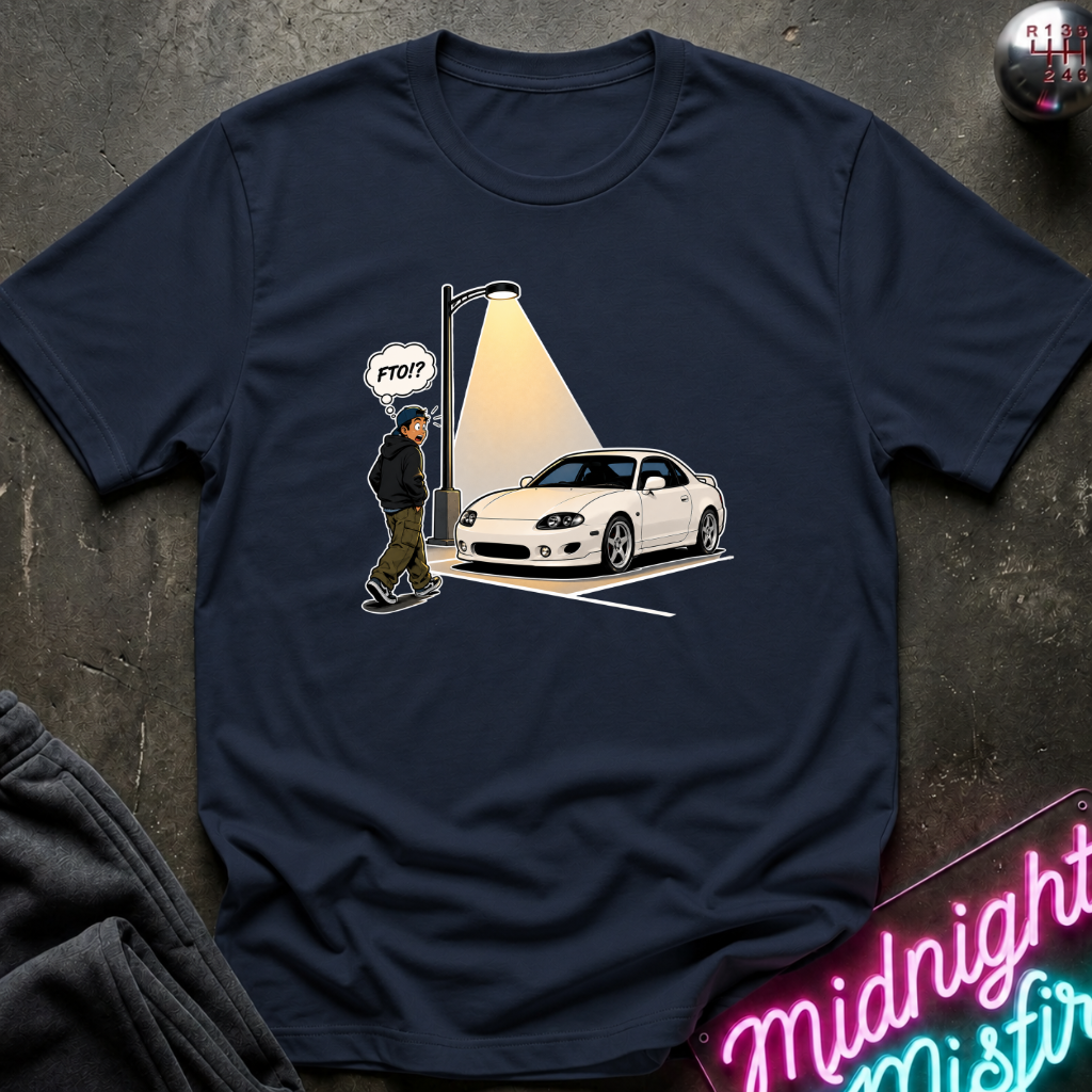A navy blue graphic t-shirt laid flat on a dark textured surface. The graphic shows a white sports car under a streetlamp.