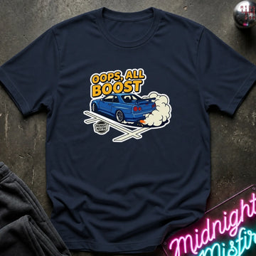 A navy blue graphic t-shirt laid flat on a dark textured surface. The graphic features a blue car with white smoke and the text 'OOPS, ALL BOOST' in yellow and white.