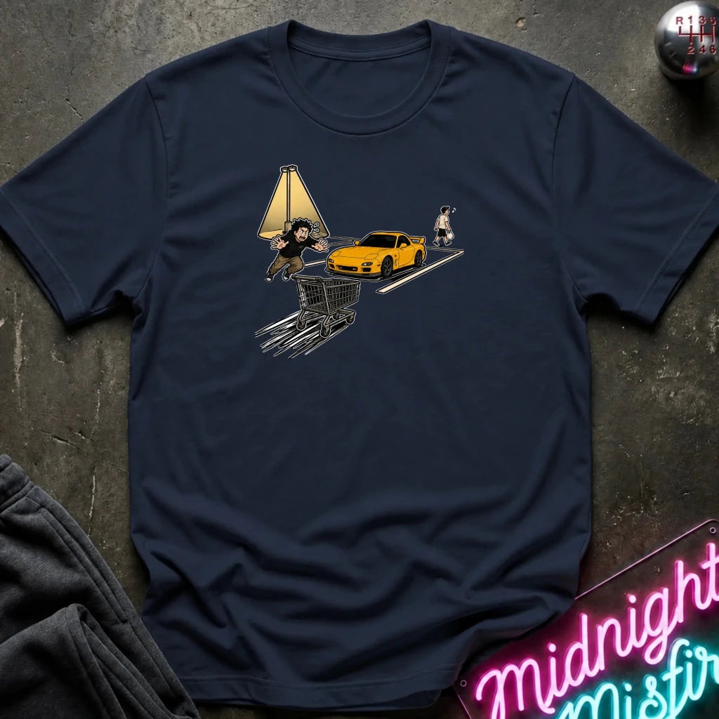 A navy blue crewneck t-shirt laid flat on a dark textured surface, featuring a graphic print of a shopping cart, a yellow sports car, and characters resembling Deadpool and Wolverine. 